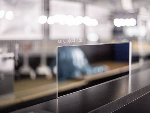 Plexiglas-Schutzscheibe mit Gravur auf einer Theke