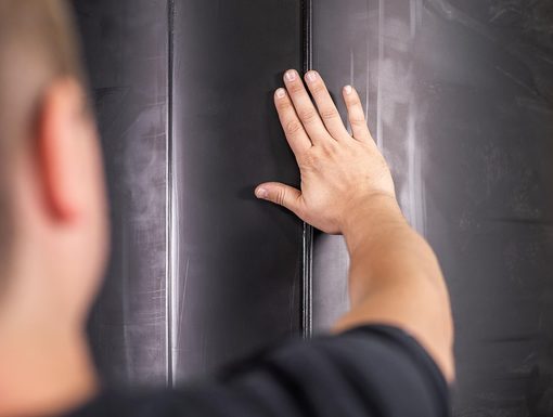 Hand prüft eine geschweisste Kunststoffwand