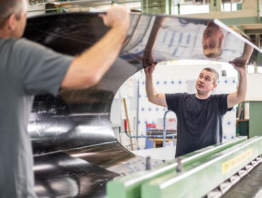 Mitarbeiter mit einer gebogenen Kunststoffplatte